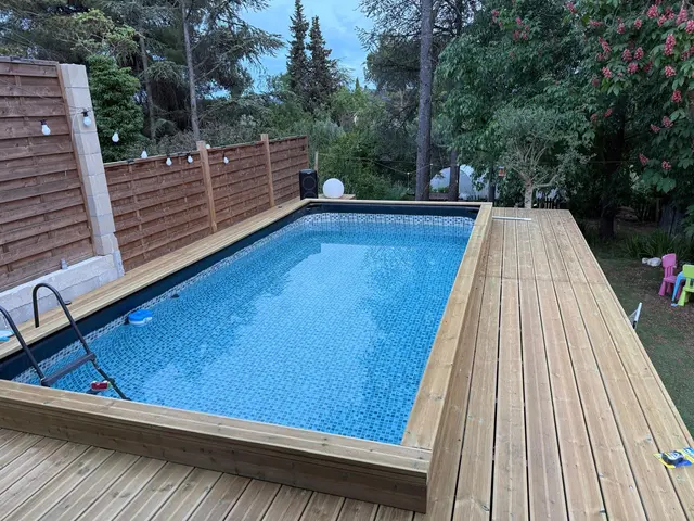Piscine et plage en bois au cœur du jardin