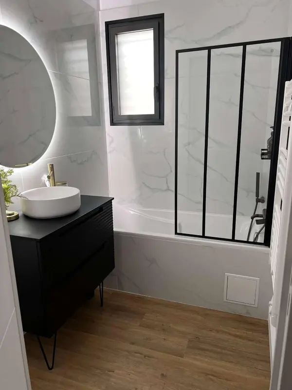 Baignoire avec pare-bain noir et carrelage mural
