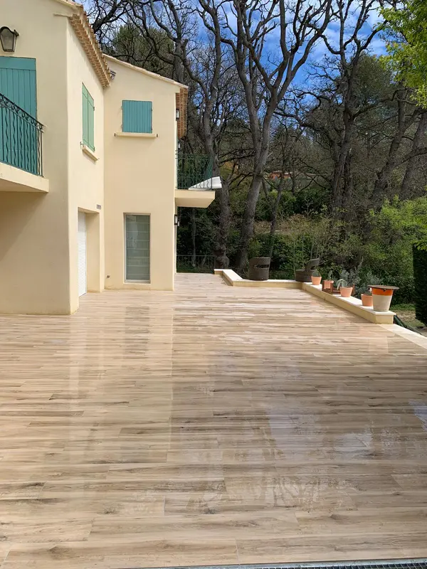 Grande terrasse en lames de bois devant la maison